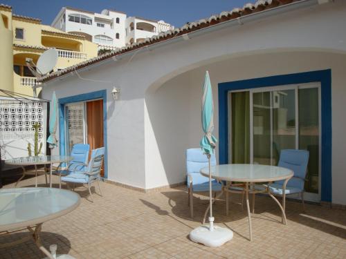 a patio with tables and chairs on a balcony at Villa Cerro in Albufeira