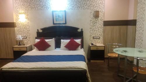 1 dormitorio con 1 cama con almohadas rojas y azules en Hotel nala residency, en Tiruvannāmalai
