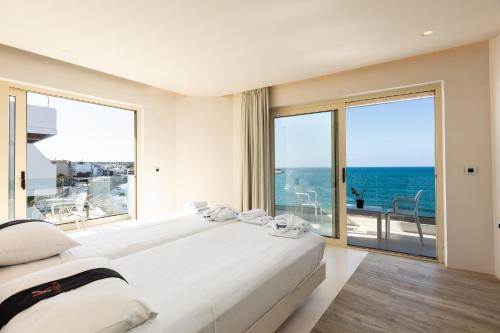 a hotel room with a balcony overlooking the ocean at Kahlua Hotel & Suites in Hersonissos