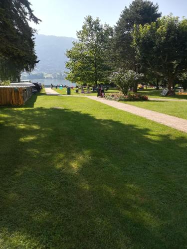 a park with a large shadow on the grass at Seeappartment Regina Bodensdorf am Ossiacher See am Fuße der Gerlitzen in Tschöran