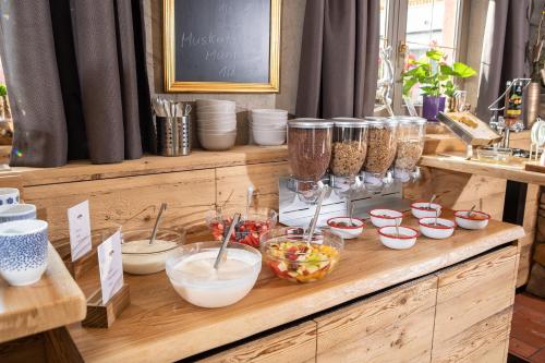 a wooden counter with bowls of food on it at Gasthof Dorfwirt Sandgruber Ges.m.b.H in Pertisau