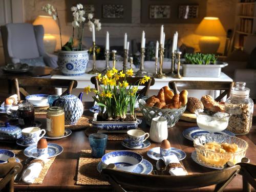une table avec de la vaisselle bleue et blanche, des œufs et des fleurs dans l'établissement Les Jardins Haute Couture, à Huismes