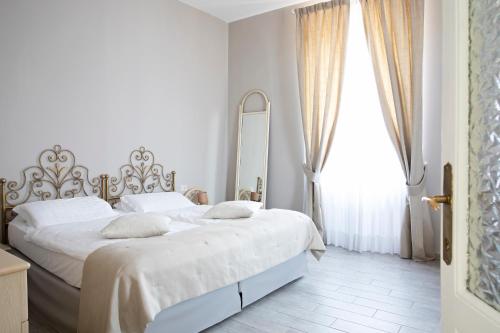 a white bedroom with a bed and a window at La Vigna in Luino