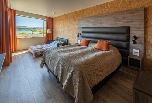 a bedroom with a large bed and a large window at Hotel Kriunes in Reykjavík