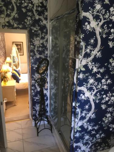 a room with a wall with blue and white wallpaper at Littlebank Country House in Settle
