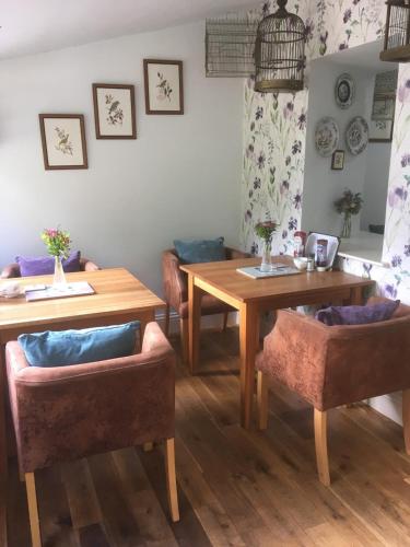 a living room with two tables and two chairs at Littlebank Country House in Settle