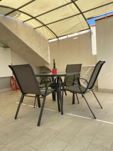 three chairs and a table with a potted plant on it at Villa Angela in Scalea