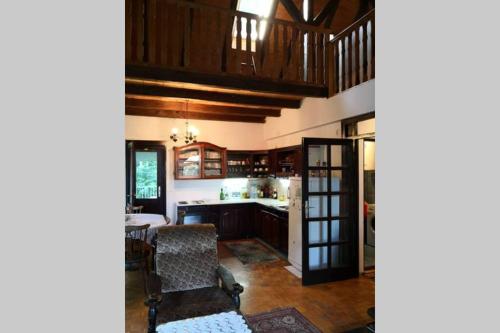 a kitchen with wooden cabinets and a dining room at Cherry Tree Villa in Bošnjaci