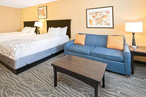 um quarto de hotel com uma cama e um sofá em La Quinta by Wyndham Logan em Logan