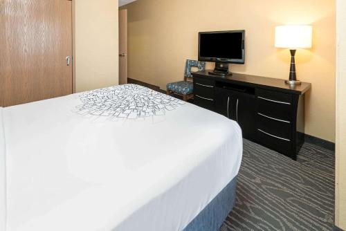 a hotel room with a bed and a flat screen tv at La Quinta by Wyndham Logan in Logan