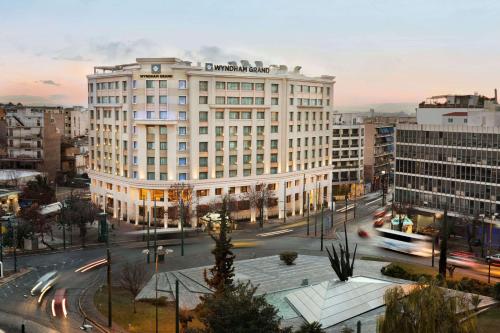 a large white building in a city with a street at Wyndham Grand Athens in Athens