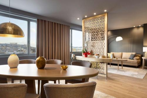 a living room with tables and chairs and a couch at Wyndham Grand Athens in Athens