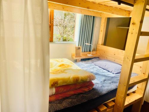 ein Schlafzimmer mit einem Etagenbett und einem Fenster in der Unterkunft Vanguard Backpackers in Sagamihara