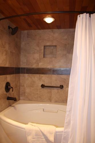 a bath tub in a bathroom with a shower curtain at The Tahoe Beach & Ski Club Owners Association in South Lake Tahoe