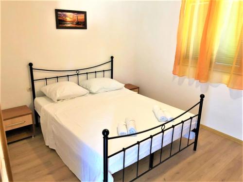 a bedroom with a bed with white sheets and shoes on it at Apartments Branka in Gornji Karin