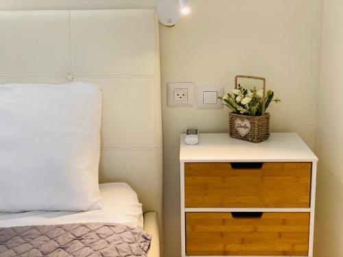 Perfect Southern Getaway with Balcony في إيلات: غرفة نوم مع سرير وطاولة مع الزهور