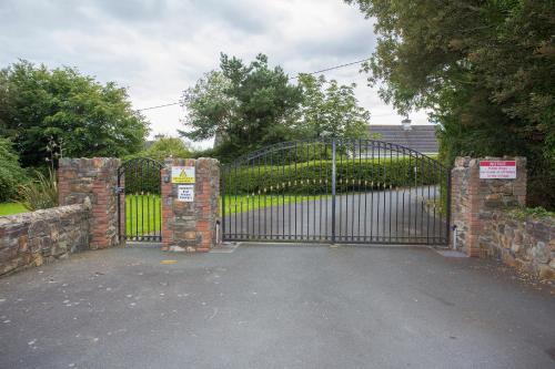 a gate to a driveway in front of a house at Brittas Bay Holiday Village No 32 by Trident Holiday Homes in Brittas Bay