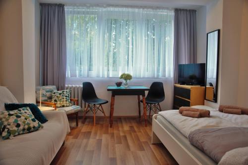 uma sala de estar com 2 camas, uma mesa e uma janela em Friendly Place Doki em Gdańsk