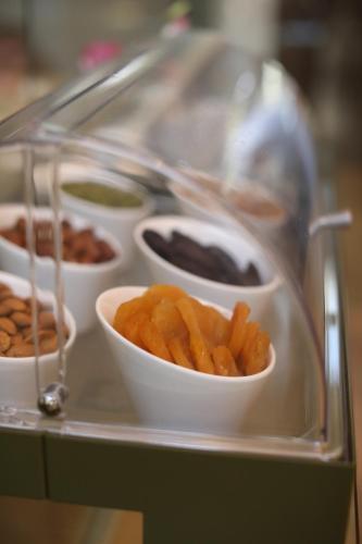 a tray with bowls of food on a buffet at Grand Hotel Yerevan - Small Luxury Hotels of the World in Yerevan