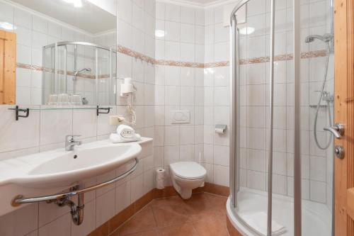 a bathroom with a sink and a toilet and a shower at Wander- und Familienhotel Erika in Wagrain