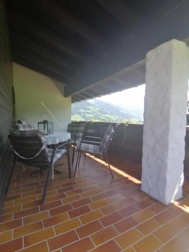 a patio with a table and chairs on a balcony at Haus Schwarzmann in Raggal