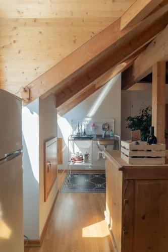 a kitchen with wooden ceilings and a wooden floor at Schloss-Castel Pienzenau - Guestrooms & Apartments - B&B-Hotel & Restaurant in Merano
