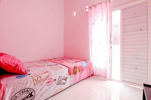 Ένα ή περισσότερα κρεβάτια σε δωμάτιο στο Pinky Guest House Syariah Kota Batu