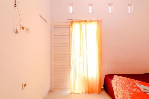 Ένα ή περισσότερα κρεβάτια σε δωμάτιο στο Pinky Guest House Syariah Kota Batu