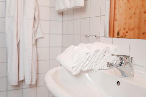 een badkamer met witte handdoeken op de wastafel bij Landhaus Kreileder in Bad Griesbach