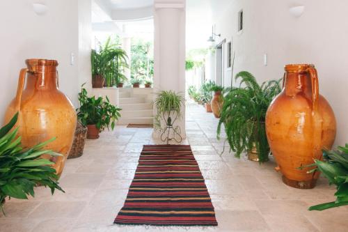 a hallway with two large orange vases and a rug at Corte dei Nobili in Conversano