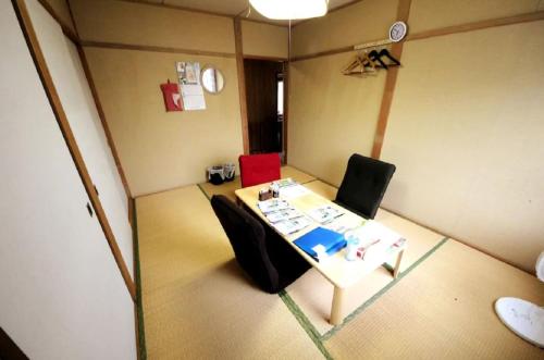 a small room with a table and two chairs at Guest House Yamada in Date