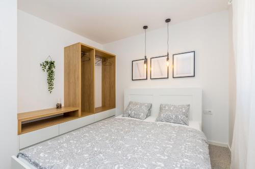a white bedroom with a bed and two pillows at Apartment LAURUS in Krk