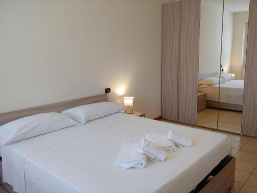 a bedroom with a large white bed with two towels at Tony Rooms & Apartments in Cavaion Veronese