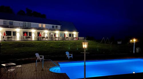 a house with a swimming pool at night at Löderup Strandbad Hotell och Restaurang in Löderup