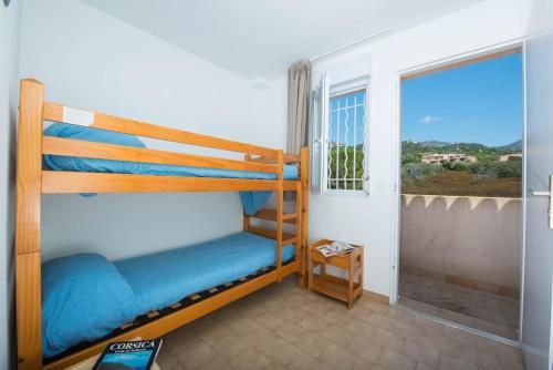a bedroom with two bunk beds and a window at Résidence Arinella in Lumio