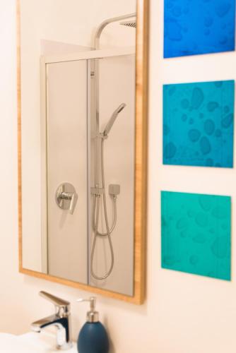 a shower in a mirror above a bathroom sink at Emma Suite Merano in Merano