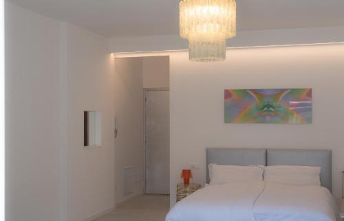 a bedroom with a bed and a chandelier at Emma Suite Merano in Merano