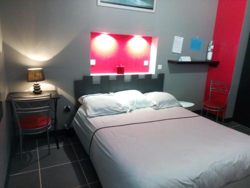 a bedroom with a bed and a red wall at La chambre du Clos Barriant in Séreilhac
