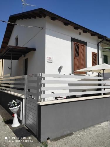 a white house with a fence and a toilet at B&B Da Daniela in Magliano deʼ Marsi