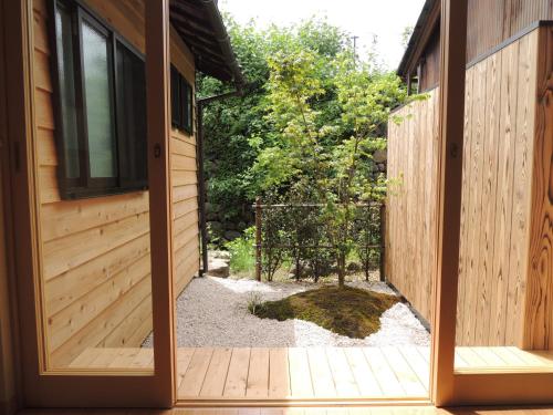 an open door to a garden with a fence at Kenroku House in Kanazawa