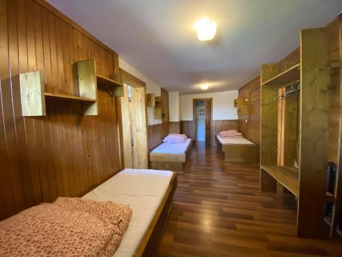 Habitación con 2 camas y paredes de madera. en Dom Pod Lasem, en Murzasichle