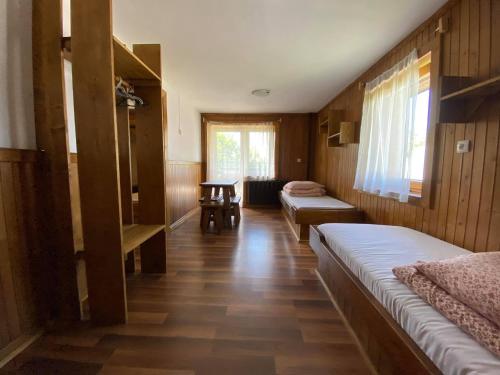 a room with two beds and a table in it at Dom Pod Lasem in Murzasichle