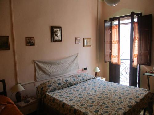 a bedroom with a bed and a door to a balcony at L'Antica Locanda in Iglesias