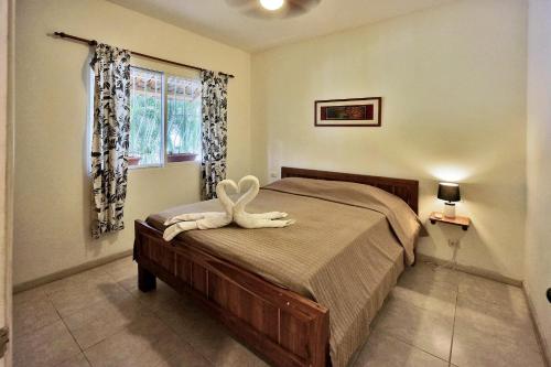 a bedroom with a bed with a white animal on it at Costa Riki Apartments in Santa Teresa Beach