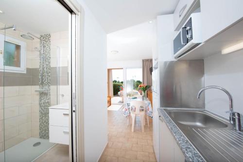 a kitchen with a sink and a table at Résidence Arinella in Lumio