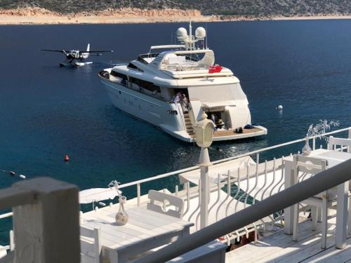 a yacht is docked on the water with a plane at Club Çapa Hotel in Kas