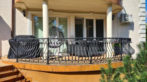 a balcony with a black railing on a house at Apartament DeLuxe 1 in Oświęcim