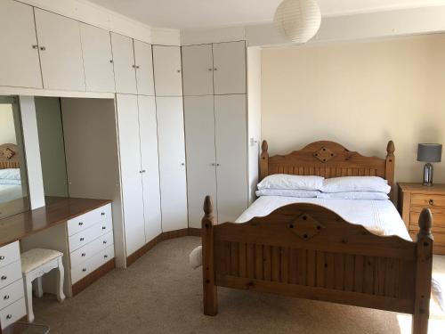 1 dormitorio con cama de madera y armarios blancos en Spacious home by the sea in Scalloway. en Scalloway