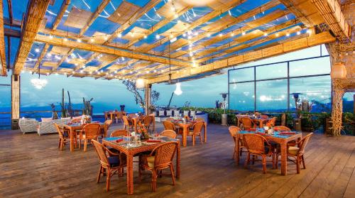 restauracja ze stołami i krzesłami oraz widokiem na ocean w obiekcie Munduk Heaven Luxury Villas w mieście Munduk