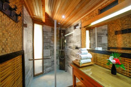 a bathroom with a shower and a sink with towels at Munduk Heaven Luxury Villas in Munduk